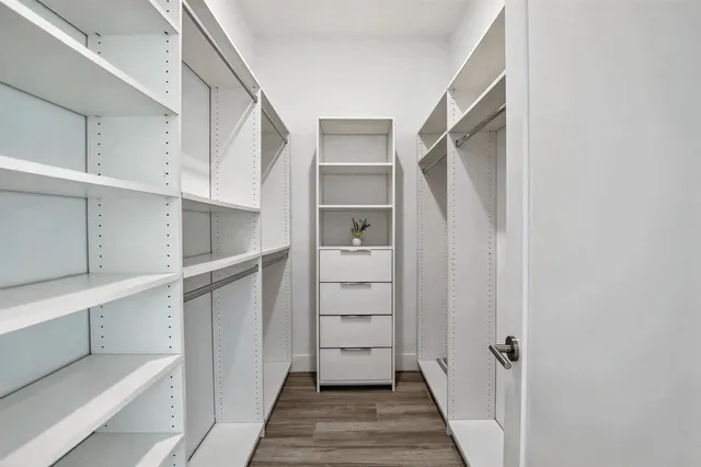 a view of walk in closet with empty racks