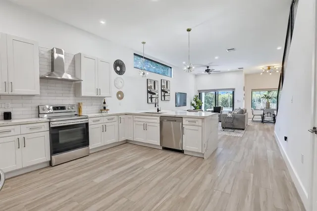 a kitchen with kitchen island white cabinets and black stainless steel appliances