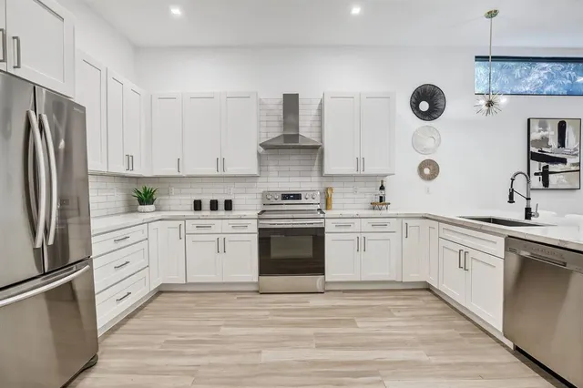 a kitchen with stainless steel appliances a refrigerator sink and cabinets