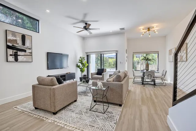 a kitchen with stainless steel appliances kitchen island granite countertop a refrigerator a stove and white cabinets with wooden floor