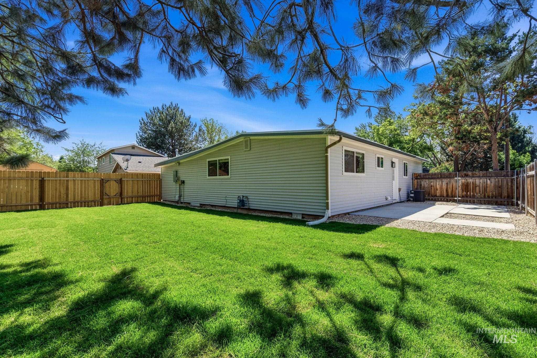 2224 Rachel Circle Boise, ID 83706 - Photo 44 of 50 Expansive backyard featuring a lush green lawn, full privacy fencing, and a concrete patio area