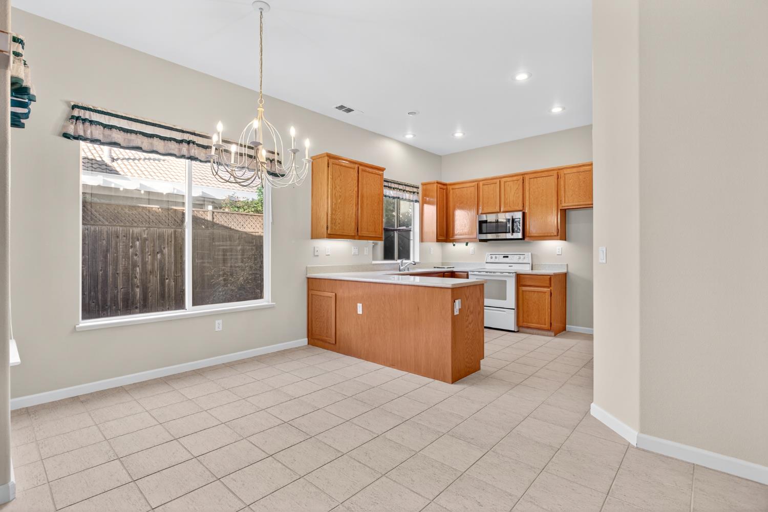 3409 Sugar Oak Court Modesto, CA 95355 - Photo 11 of 28 a kitchen with stainless steel appliances a sink window and cabinets
