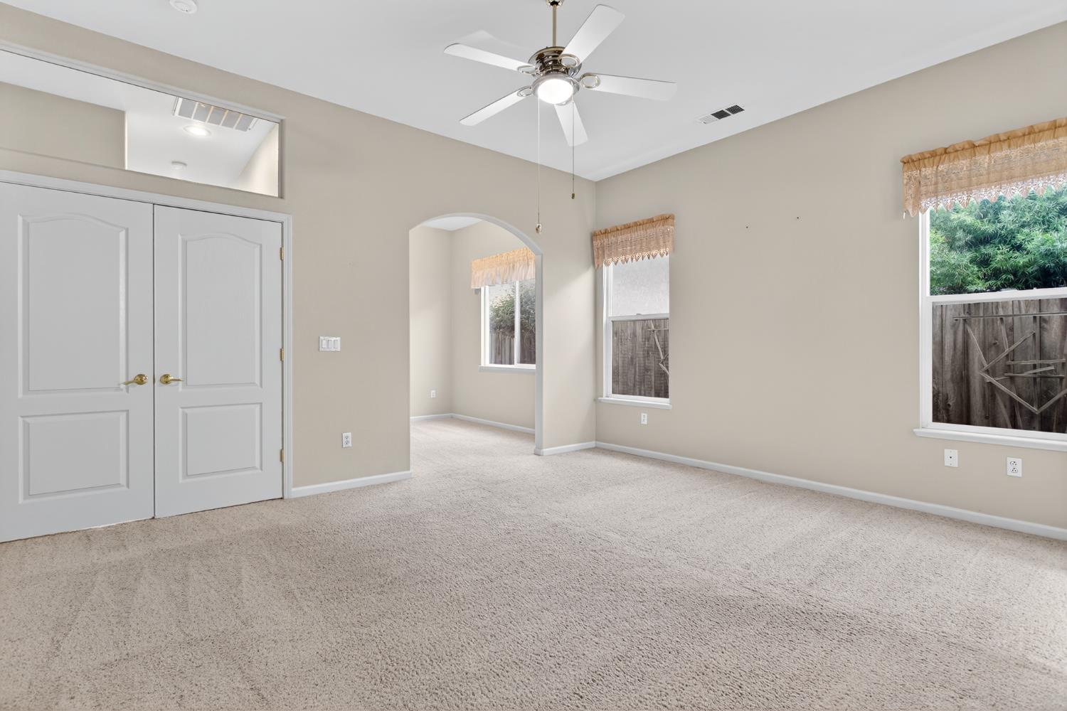 3409 Sugar Oak Court Modesto, CA 95355 - Photo 17 of 28 an empty room with chandelier fan and windows