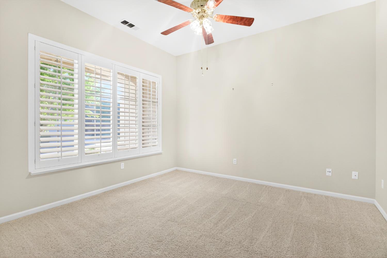 3409 Sugar Oak Court Modesto, CA 95355 - Photo 7 of 28 an empty room with a window and a fan