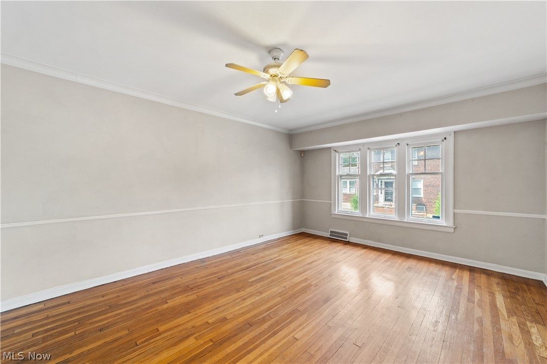 3076 Yorkshire Road Cleveland, OH 44118 - Photo 6 of 47 Spare room with hardwood / wood-style flooring, ornamental molding, and ceiling fan