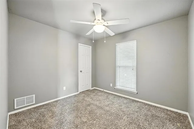 an empty room with fan and windows
