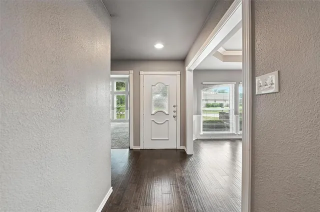 an entryway with wooden floor and windows