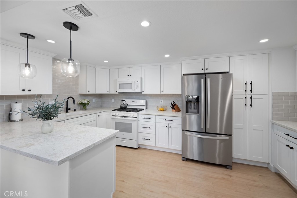 910 Ocean View Avenue, Unit E Monrovia, CA 91016 - Photo 14 of 39 a kitchen with white cabinets and stainless steel appliances