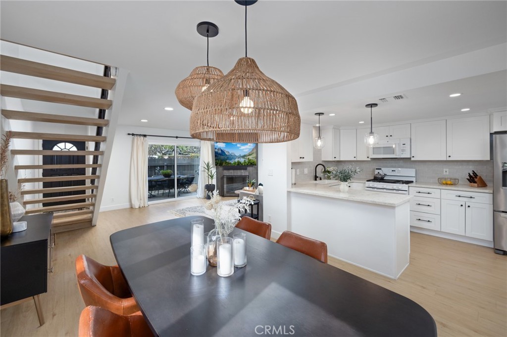 910 Ocean View Avenue, Unit E Monrovia, CA 91016 - Photo 9 of 39 a open kitchen with stainless steel appliances granite countertop a stove top oven a dining table and chairs with wooden floor
