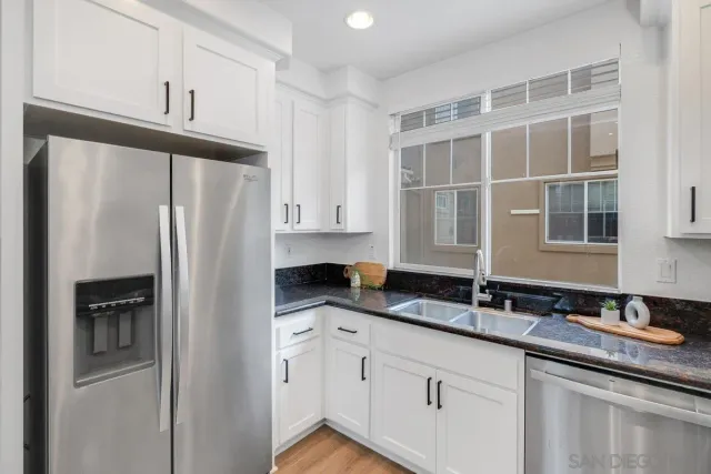 a kitchen with granite countertop a refrigerator and a sink