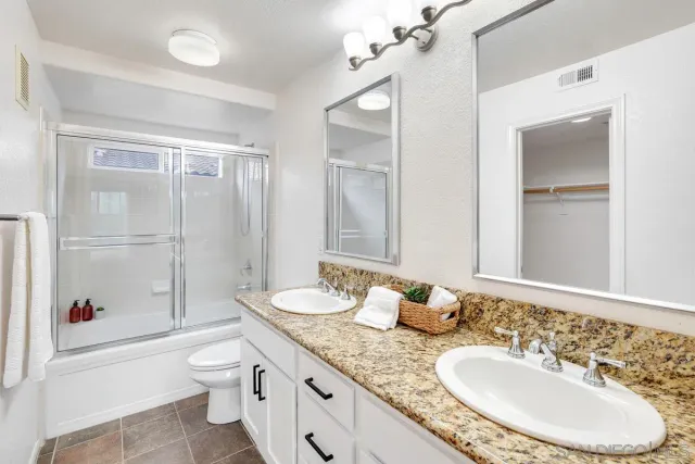 a bathroom with a granite countertop sink toilet and shower