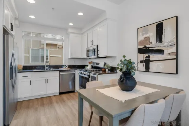 a kitchen with a stove a sink and a white cabinets