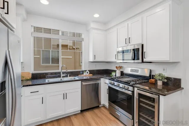 a kitchen with stainless steel appliances granite countertop a sink stove and cabinets