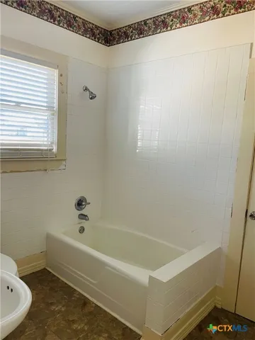 a bathroom with a bathtub and a shower
