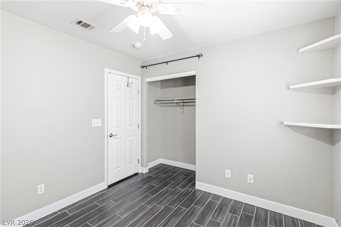 9523 Observer Street Las Vegas, NV 89123 - Photo 25 of 42 Well-lit room features built-in shelving, a spacious closet, and a ceiling fan for comfort.