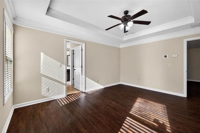 an empty room with wooden floor a ceiling fan and closet