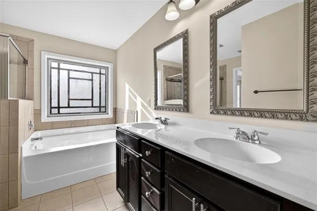 a bathroom with a granite countertop sink and a bathtub