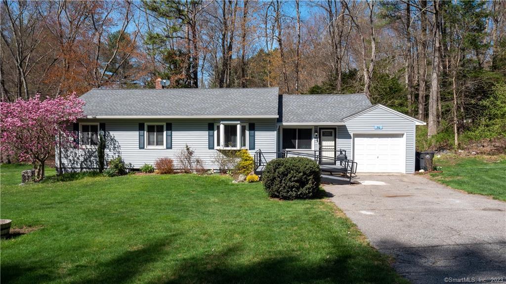 a front view of a house with a garden and trees