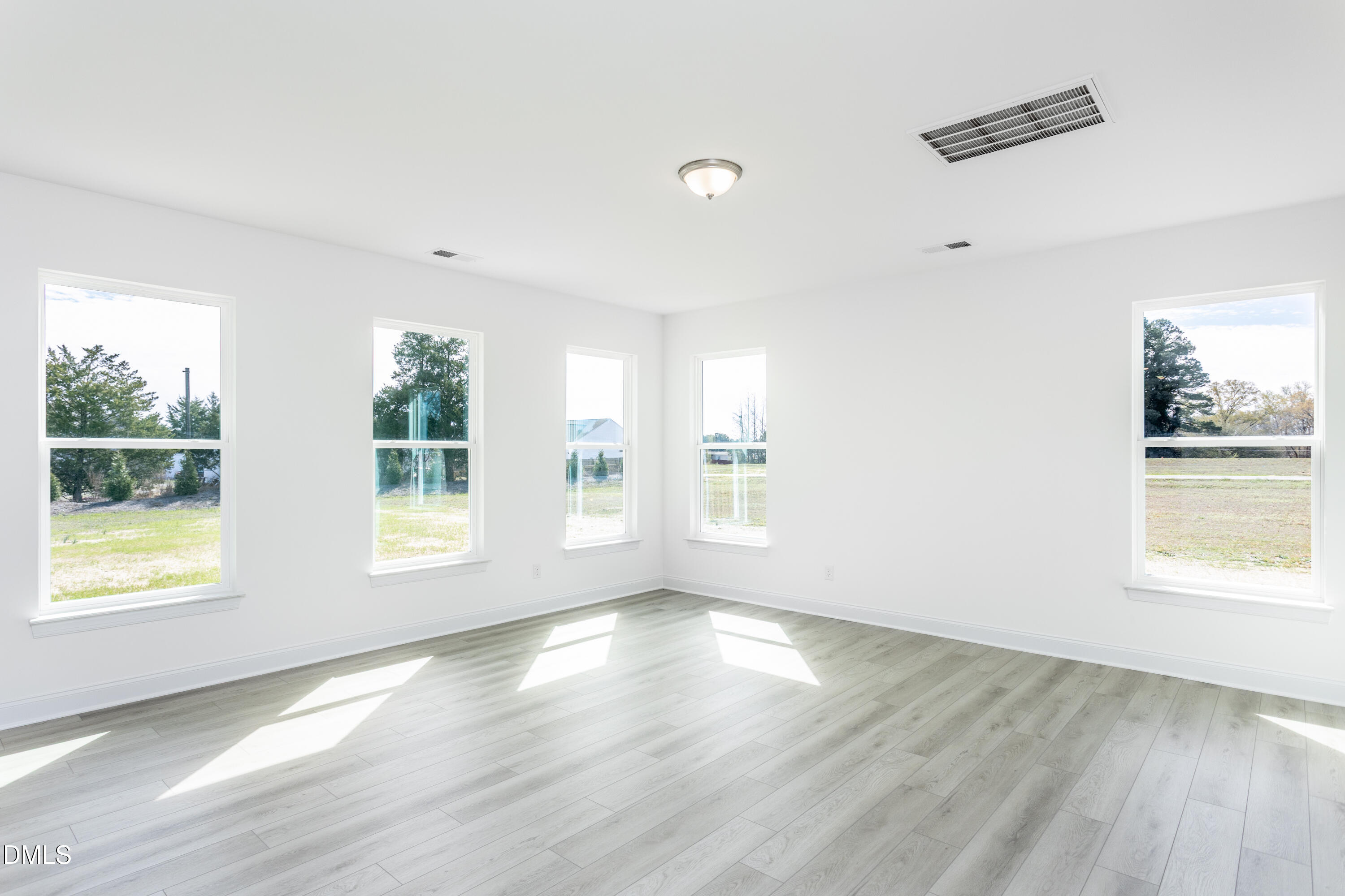 102 Bittersweet Trail Benson, NC 27504 - Photo 6 of 30 a view of an empty room with wooden floor and a window