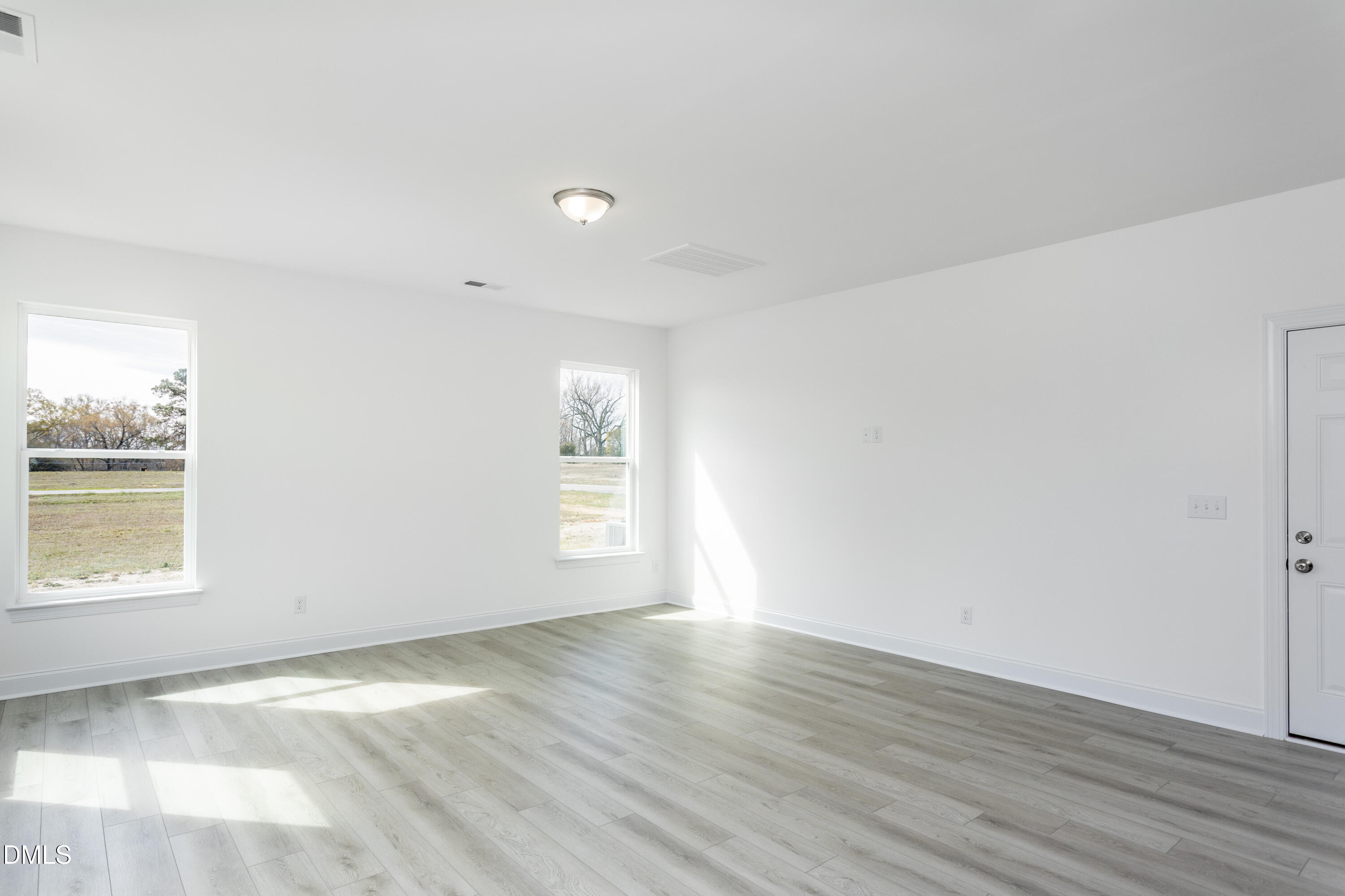 102 Bittersweet Trail Benson, NC 27504 - Photo 9 of 30 an empty room with wooden floor and windows