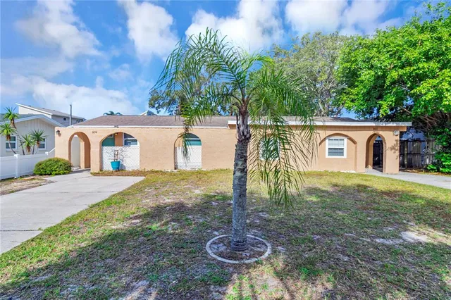 a view of a house with backyard and a tree