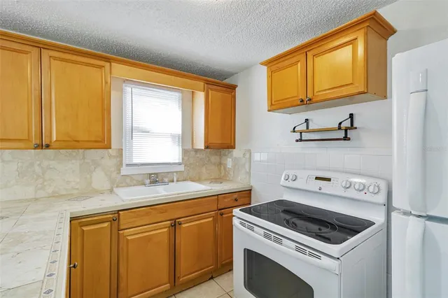 a kitchen with stainless steel appliances granite countertop cabinets and a window