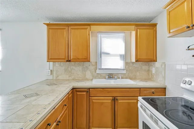 a kitchen with granite countertop cabinets sink and window
