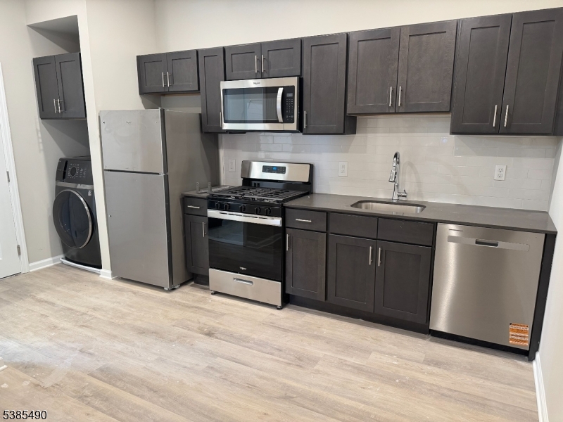 10 East Washington Avenue, Unit 202 Washington, NJ 07882 - Photo 2 of 4 a kitchen with stainless steel appliances granite countertop a refrigerator stove a sink and dishwasher