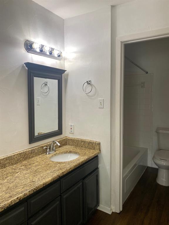 13652 Flagstone Lane Dallas, TX 75240 - Photo 10 of 15 Full bathroom with vanity, washtub / shower combination, and dark wood-style floors