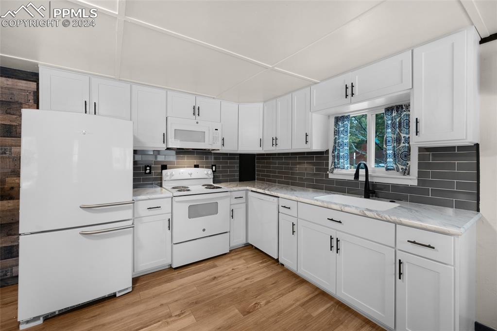 53 Iris Road Woodland Park, CO 80863 - Photo 12 of 27 a kitchen with granite countertop white cabinets and white appliances