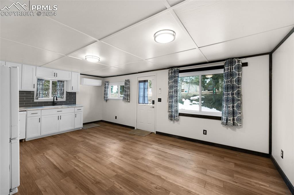 53 Iris Road Woodland Park, CO 80863 - Photo 10 of 27 a view of a big room with wooden floor and windows