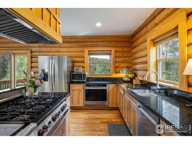 a kitchen with stainless steel appliances kitchen island granite countertop a stove and a sink