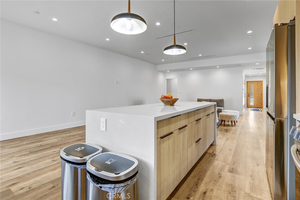 6900 Corbin Avenue Reseda, CA 91335 - Photo 23 of 50 a kitchen with stainless steel appliances a white center island a stove a chimney a sink and cabinets