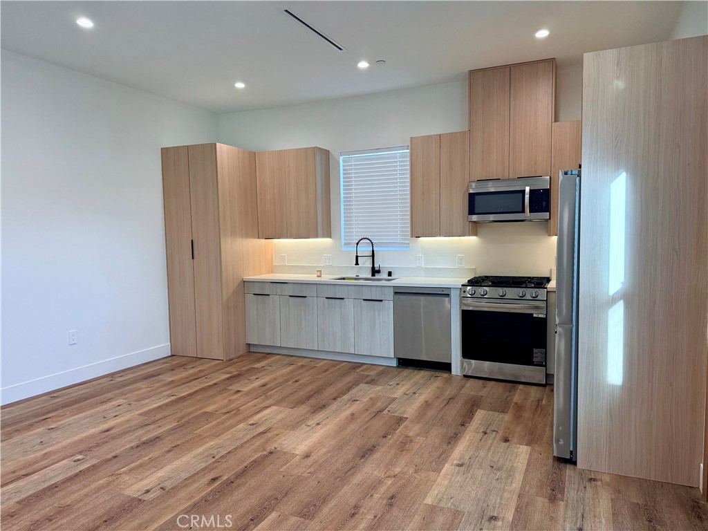6900 Corbin Avenue Reseda, CA 91335 - Photo 28 of 50 a kitchen with stainless steel appliances a sink cabinets and wooden floor