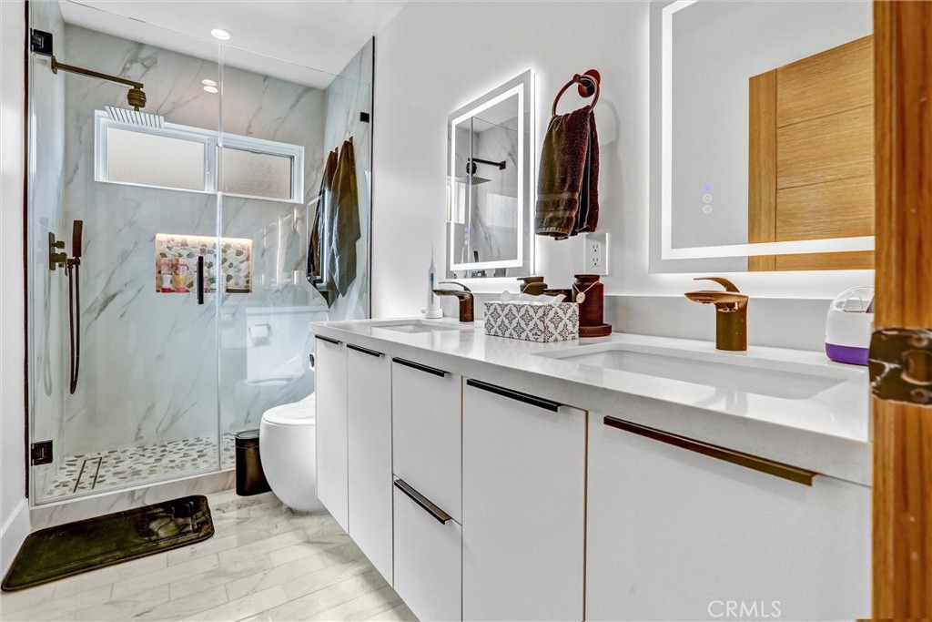 6900 Corbin Avenue Reseda, CA 91335 - Photo 3 of 50 a bathroom with a double vanity sink a toilet and a mirror