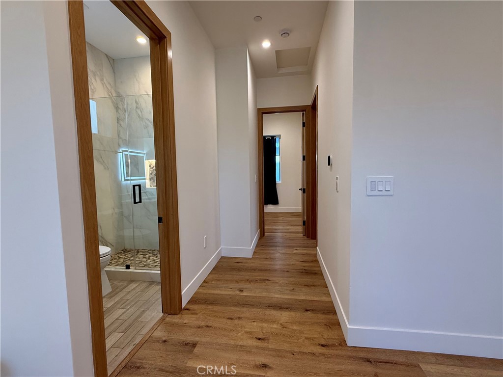6900 Corbin Avenue Reseda, CA 91335 - Photo 36 of 50 a view of a hallway with wooden floor and a bathroom