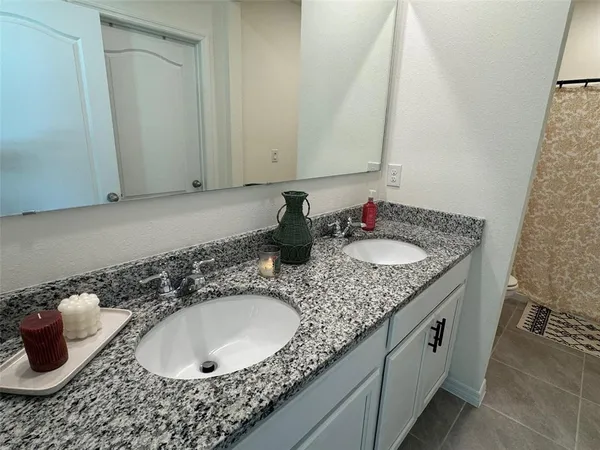 a bathroom with a granite countertop sink and a mirror