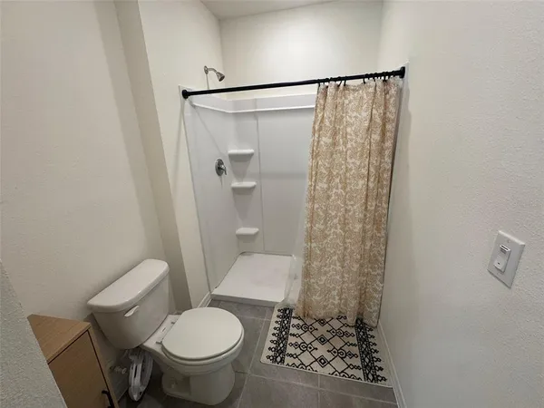 a white toilet sitting next to a shower curtain