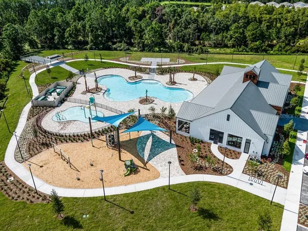 an aerial view of a house with a yard swimming pool and outdoor seating