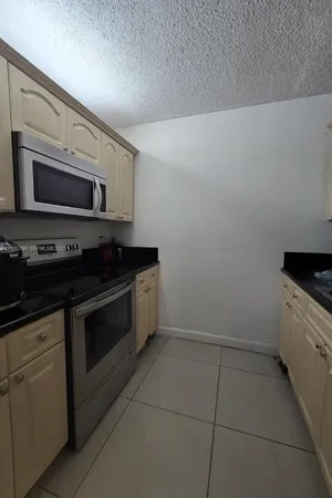 a kitchen with granite countertop white cabinets stainless steel appliances and a sink