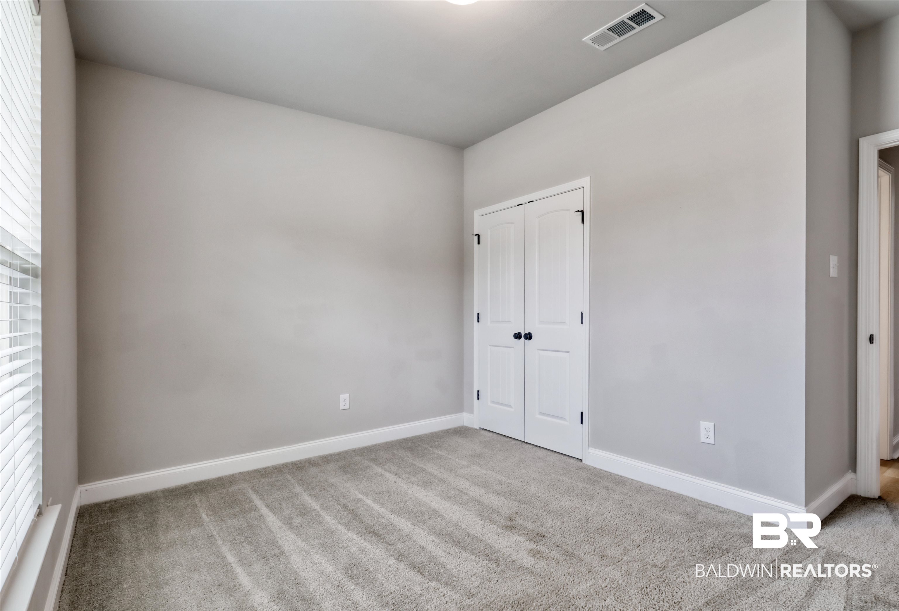 987 Gibson Court Foley, AL 36535 - Photo 25 of 34 Unfurnished bedroom featuring carpet floors, baseboards, and visible vents