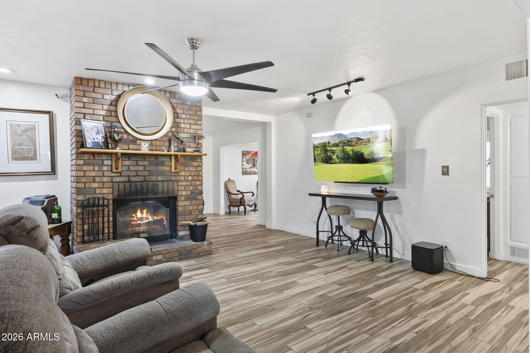 1607 West Whitton Avenue Phoenix, AZ 85015 - Photo 10 of 45 a living room with furniture a fireplace and a flat screen tv
