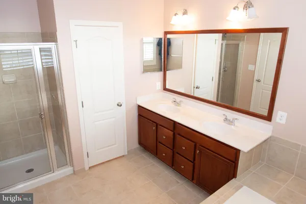a bathroom with a double vanity sink and a mirror