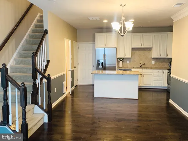 a large kitchen with cabinets a sink a window and stainless steel appliances