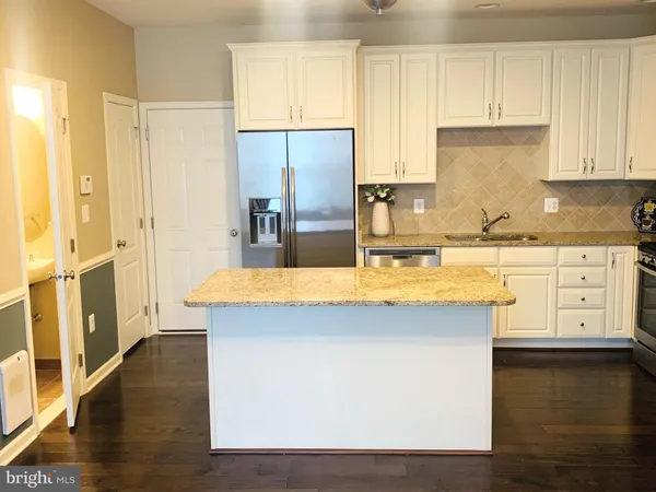 a kitchen with stainless steel appliances granite countertop a sink a stove and a refrigerator
