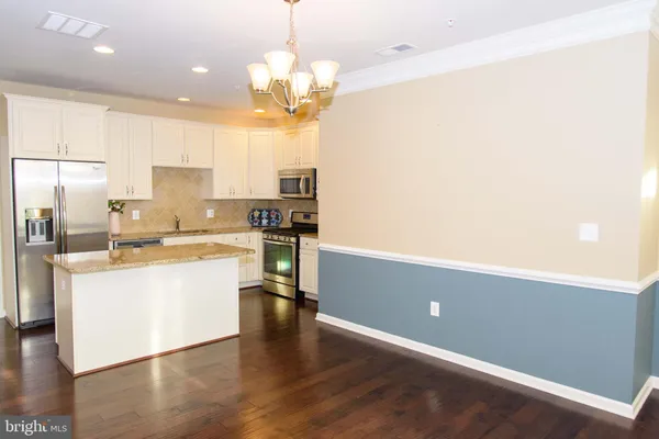a large kitchen with cabinets wooden floor and stainless steel appliances
