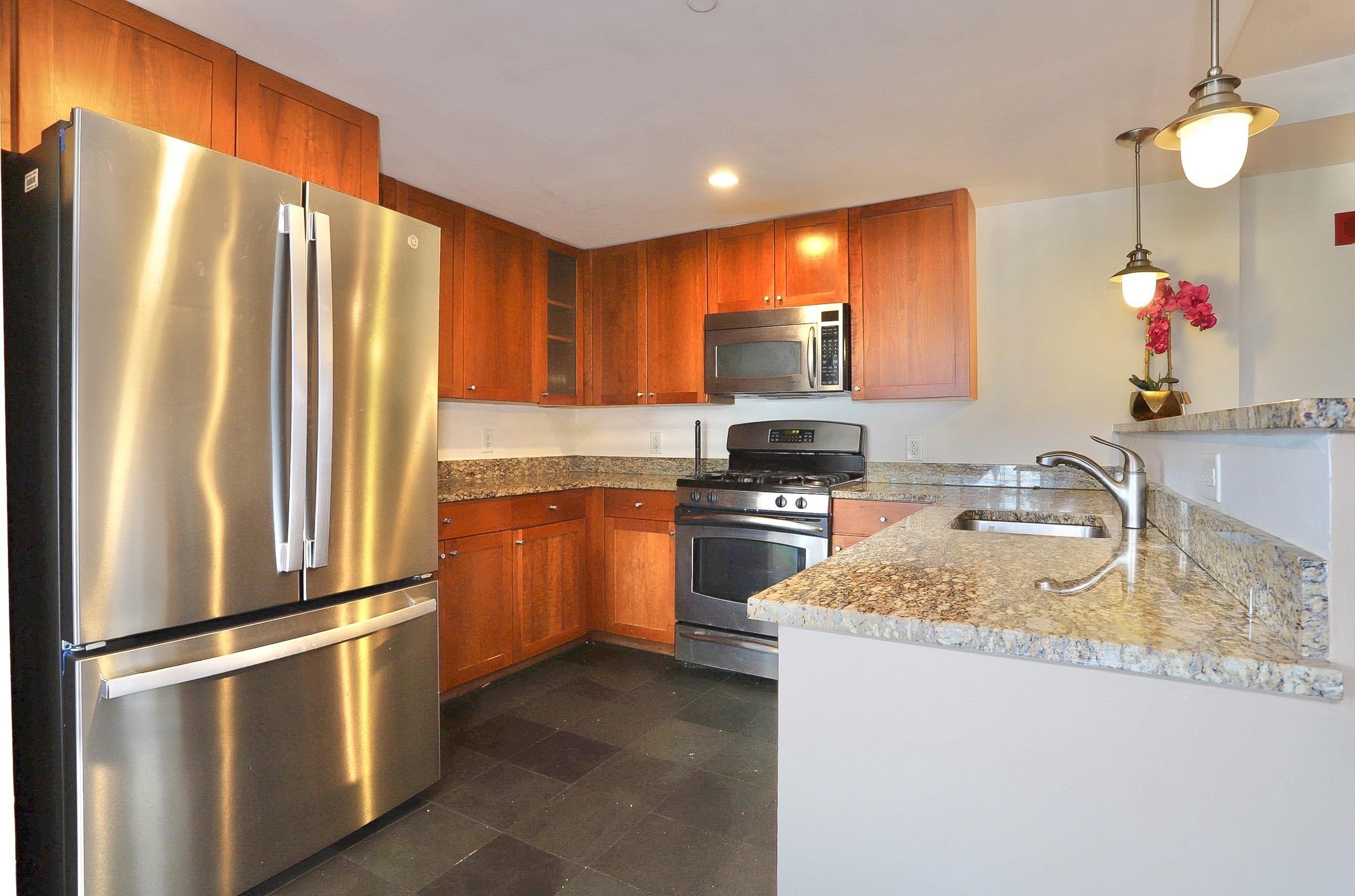 700 Grove Street, Unit 4F Jersey City, NJ 07310 - Photo 10 of 30 a kitchen with stainless steel appliances granite countertop a refrigerator a stove top oven a sink and dishwasher