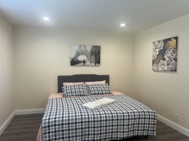 a bedroom with a bed and wooden floor