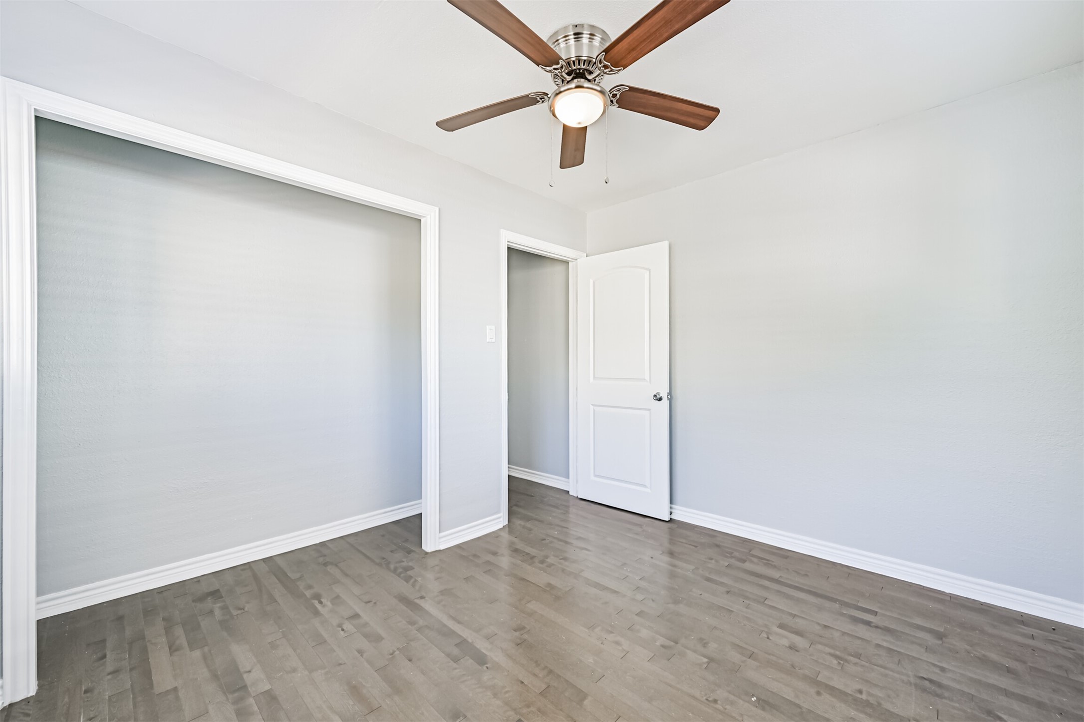 1310 Rosenberg Street Galveston, TX 77550 - Photo 40 of 50 an empty room with wooden floor ceiling fan and window