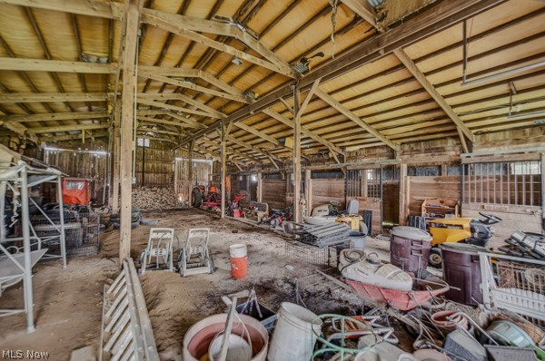 8675 West Smith Road Medina, OH 44256 - Photo 19 of 25 Spacious barn interior featuring exposed wood beams and posts, horizontal wood plank walls, and a dirt floor